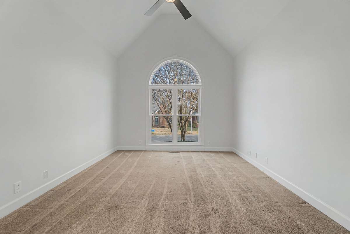 As you walk in the front door, to your right is the original primary suite with new ceiling fan.
