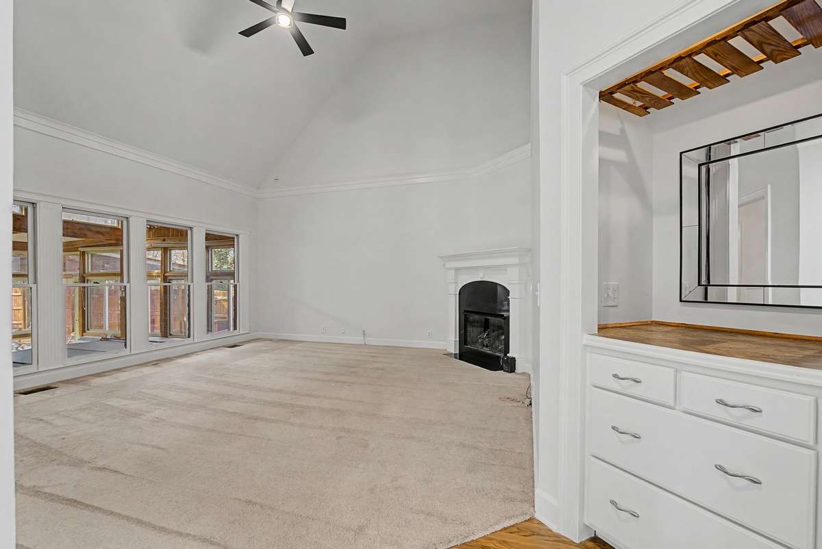 Great room with gas fireplace and a new ceiling fan.