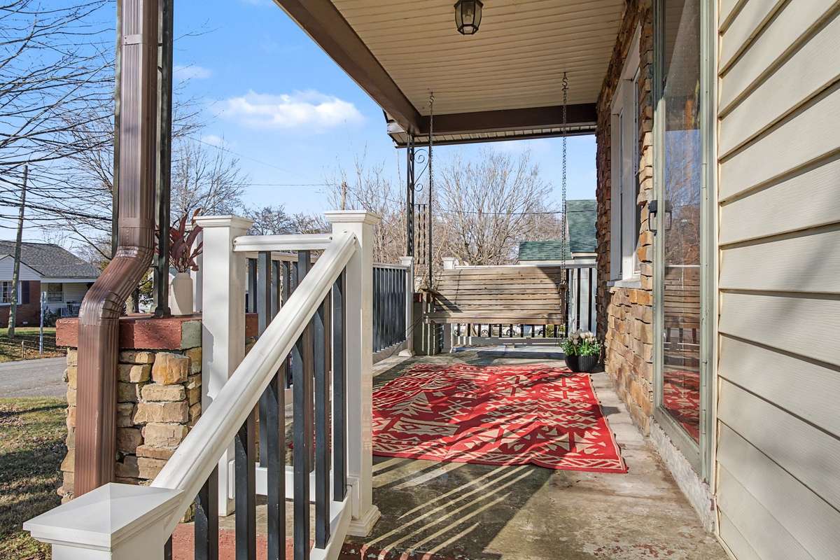 Spacious front porch with a swing (bigger rug needed :-)