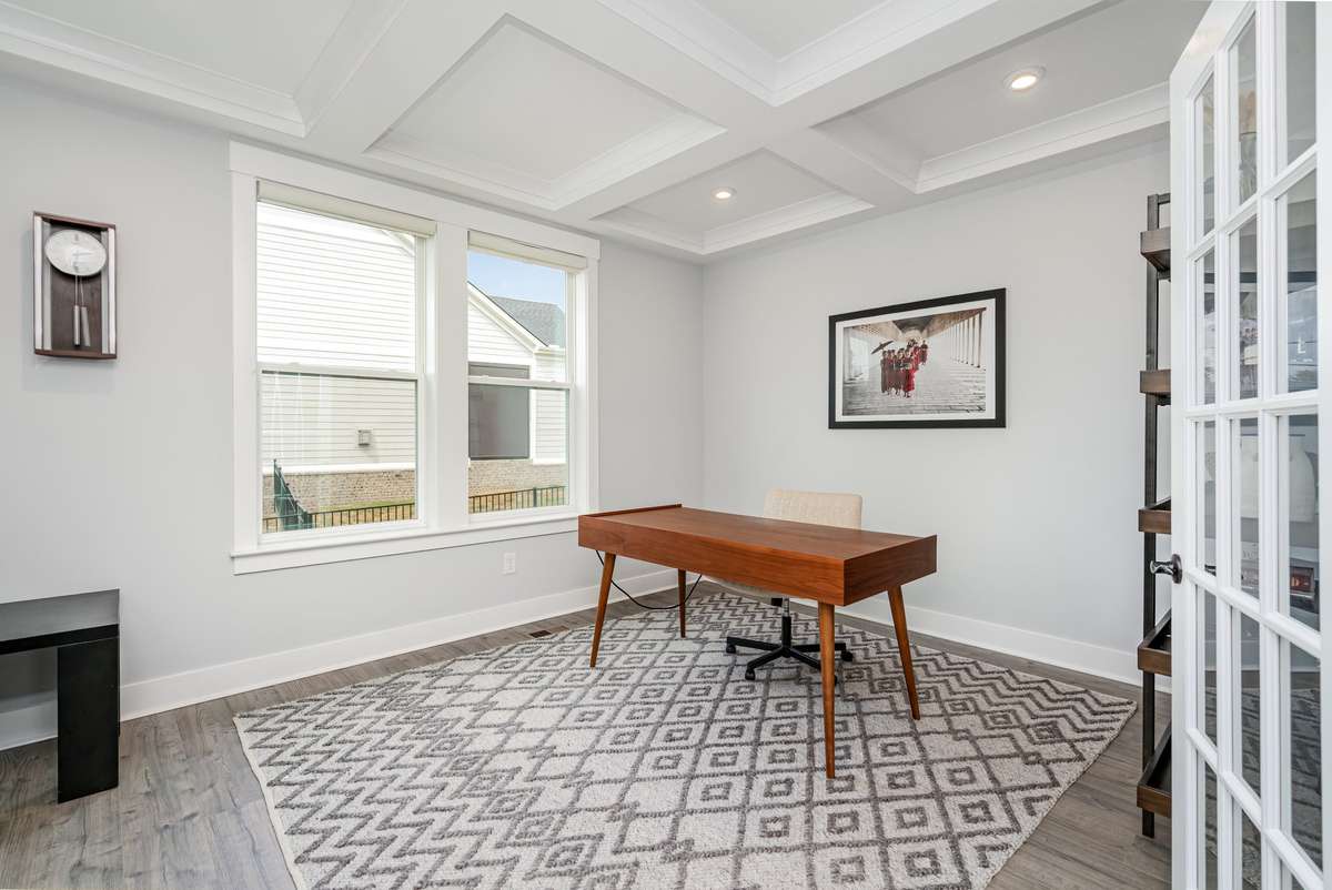 Professional home office with elegant French doors and custom coffered ceilings—ideal for a quiet work-from-home retreat.