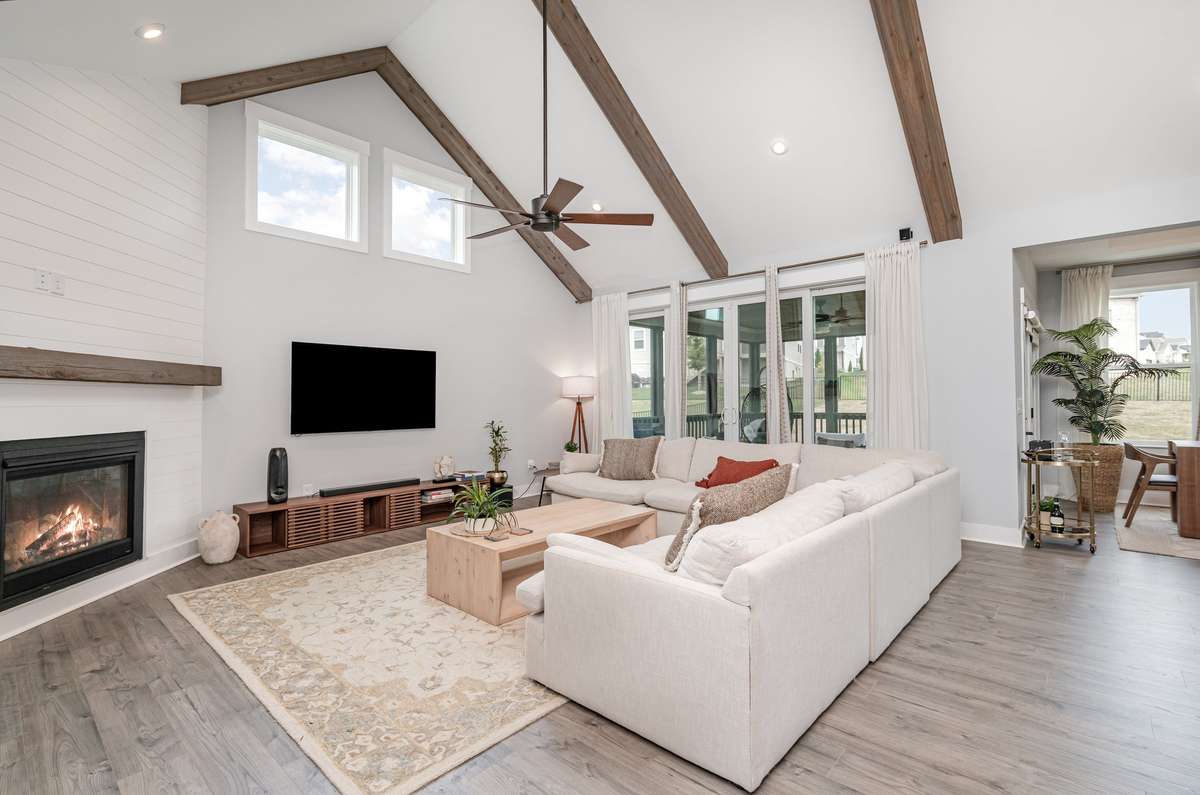 Soaring vaulted ceilings accented by rustic cedar beams and a designer shiplap fireplace create a warm, luxury atmosphere.