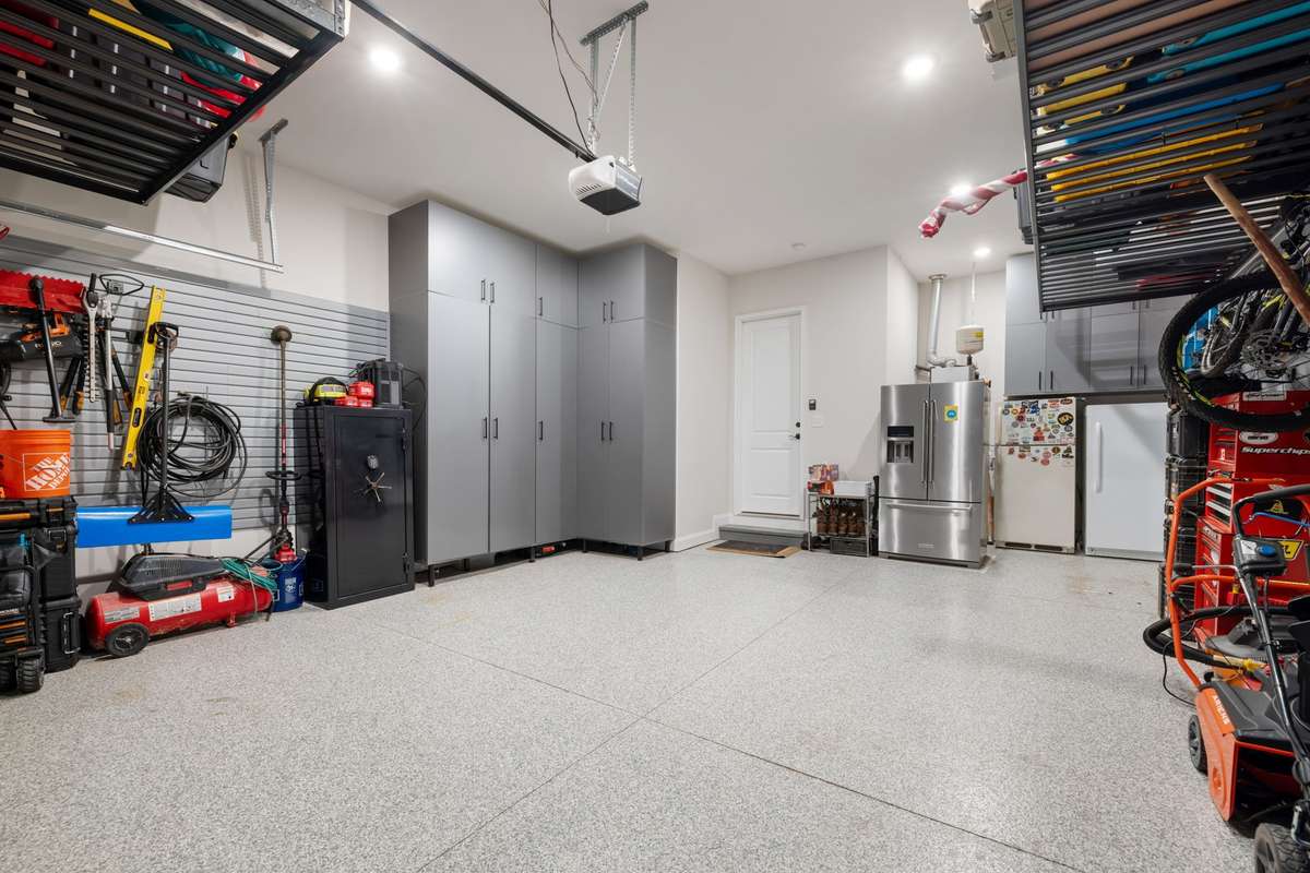Garage with custom storage and apoxy flooring. With all of this storage, you can still fit 2 SUVs inside.