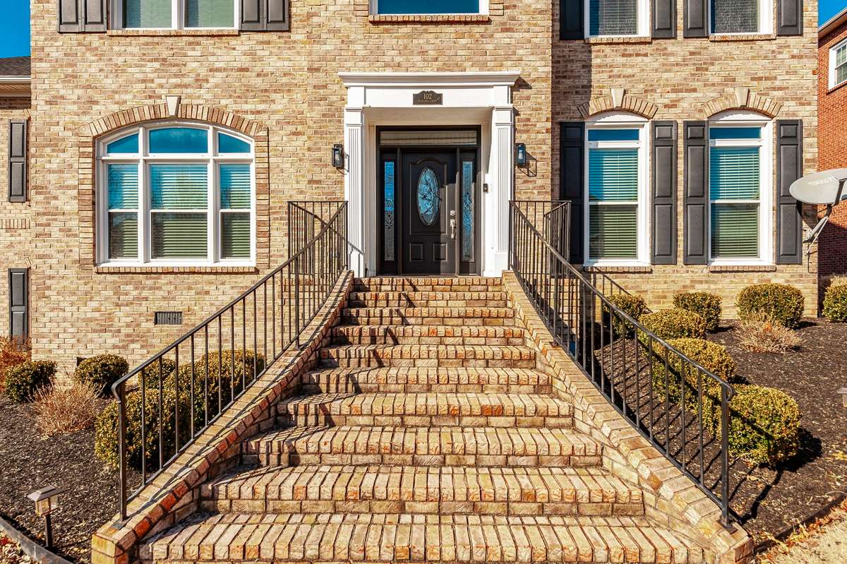 This welcoming flared brick staircase is architecturally appealing and compliments the decorative brick and keystones around windows.