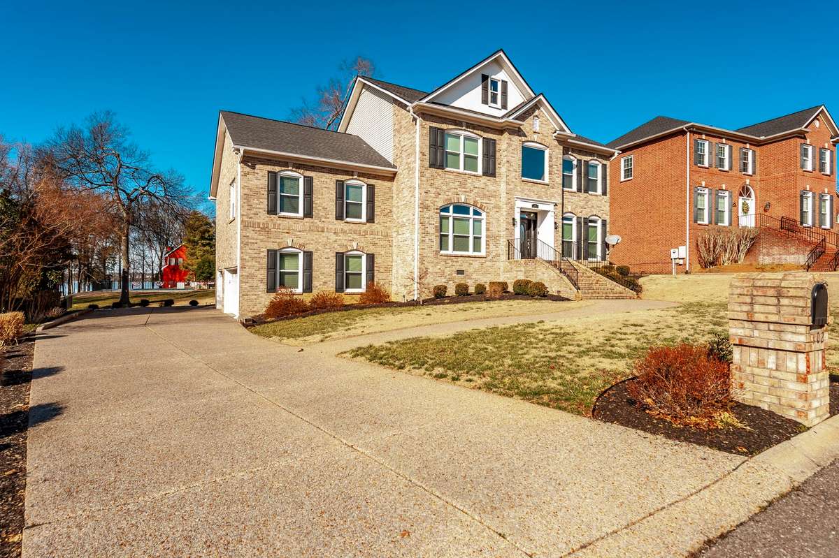 Aggregate driveway and sidewalk lead up to this sophisticated and architecturally appealing brick staircase welcoming guests to the main entry. Replacement windows and 30 year roof all taken care of for years of future enjoyment and peace of mind