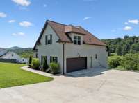 A side view showing the large 2-car garage and LOTS of concrete pad for parking!