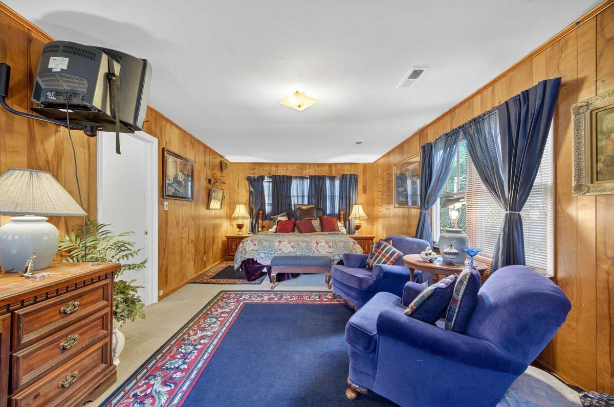 Alternate view of the spacious primary bedroom, highlighting the dedicated sitting area, room for furnishings, and flexible layout with natural light; furnishings may be included, partially included, or removed based on buyer preference.