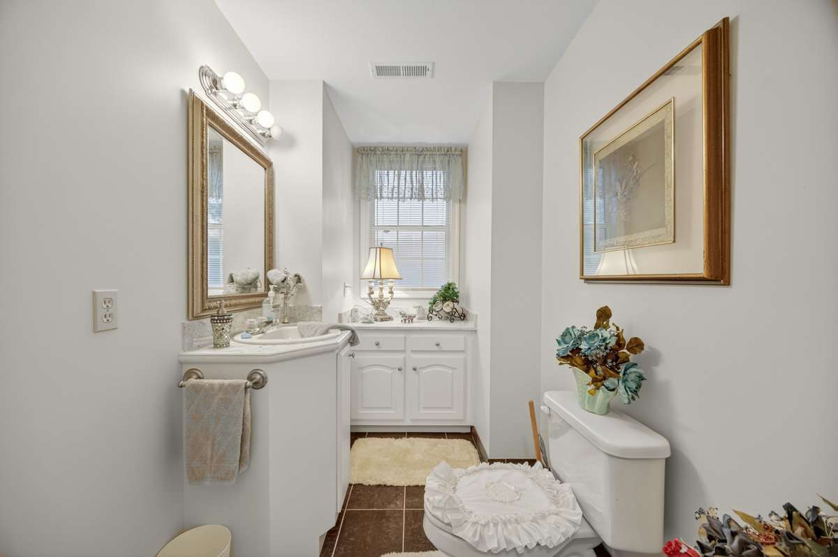 Upstairs guest powder room featuring a clean, functional layout with ample vanity space and natural light; furnishings may be included, partially included, or removed based on buyer preference.
