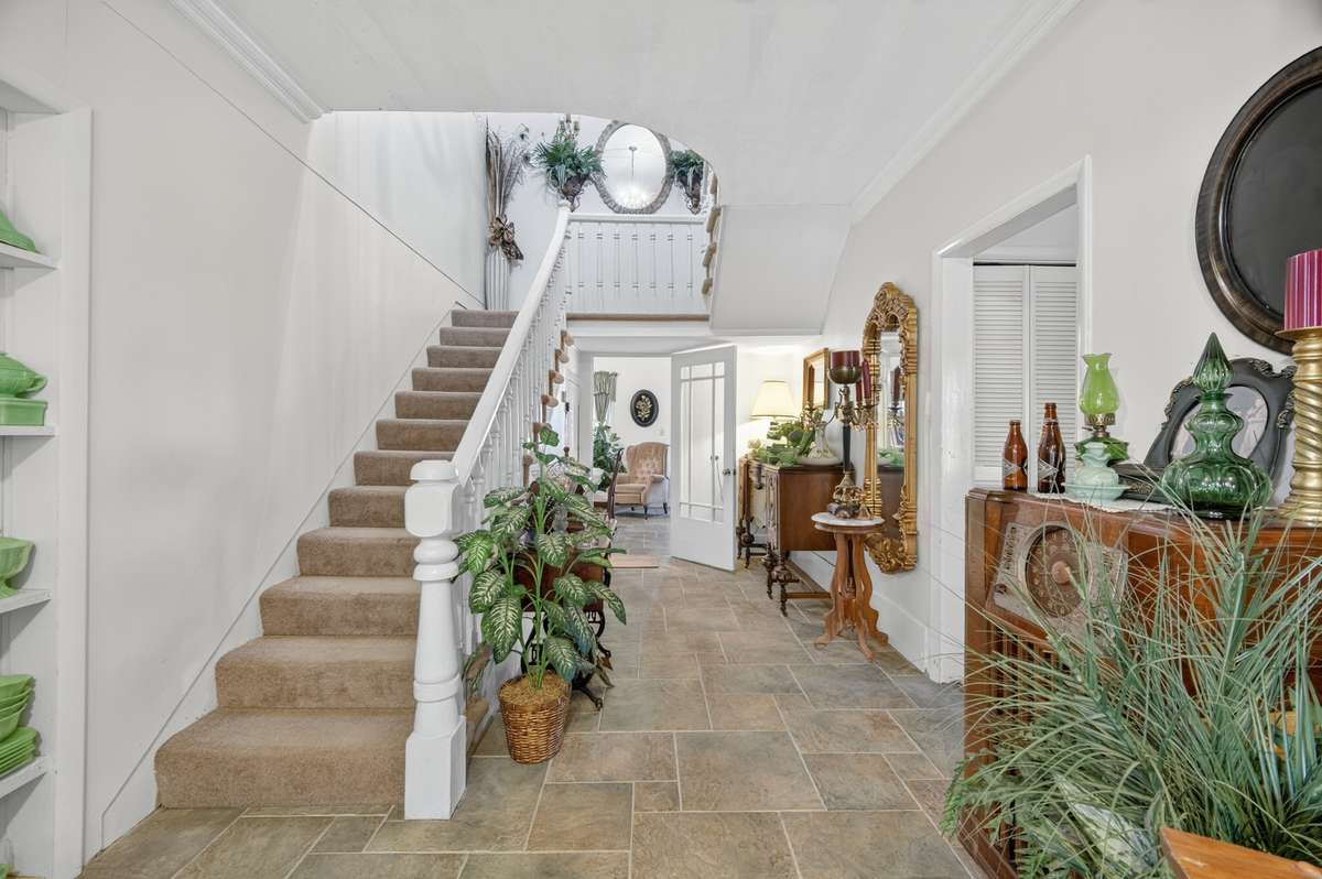 Central staircase serving as the heart of the home, offering open sightlines between levels and easy access to adjoining living spaces; furnishings may be included, partially included, or removed based on buyer preference.