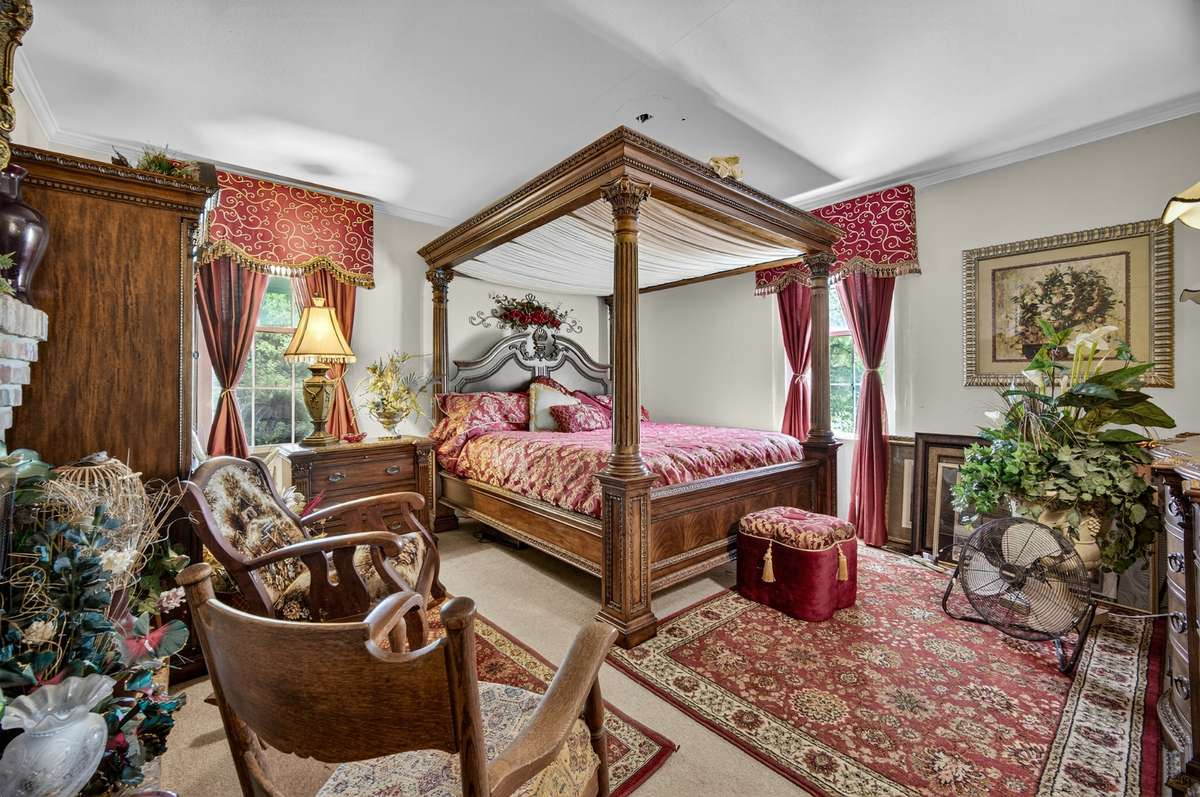 Additional main-level guest bedroom featuring a fireplace, generous space for a full bedroom setup, and classic details throughout; furnishings may be included, partially included, or removed based on buyer preference.