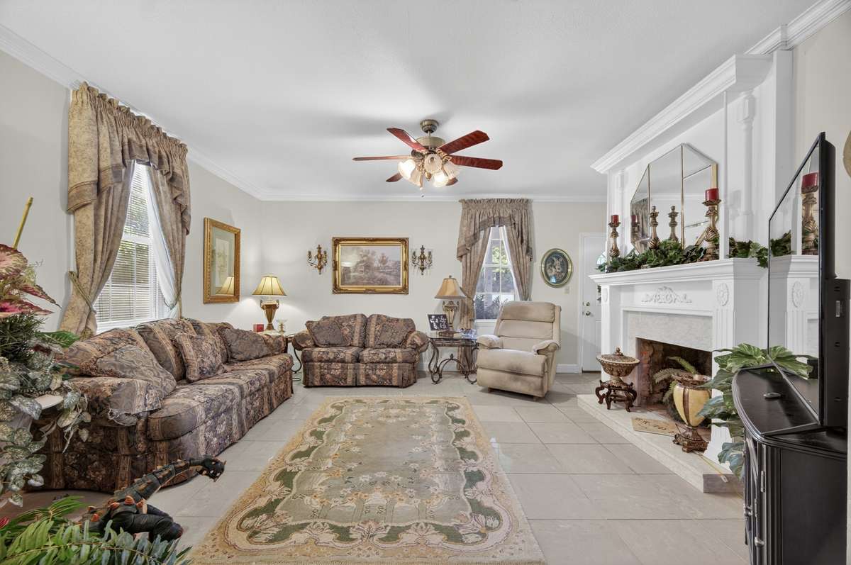 nviting living room with fireplace focal point, generous seating area, and easy flow to adjacent spaces—ideal for everyday living or entertaining; furnishings may be included, partially included, or removed based on buyer preference.
