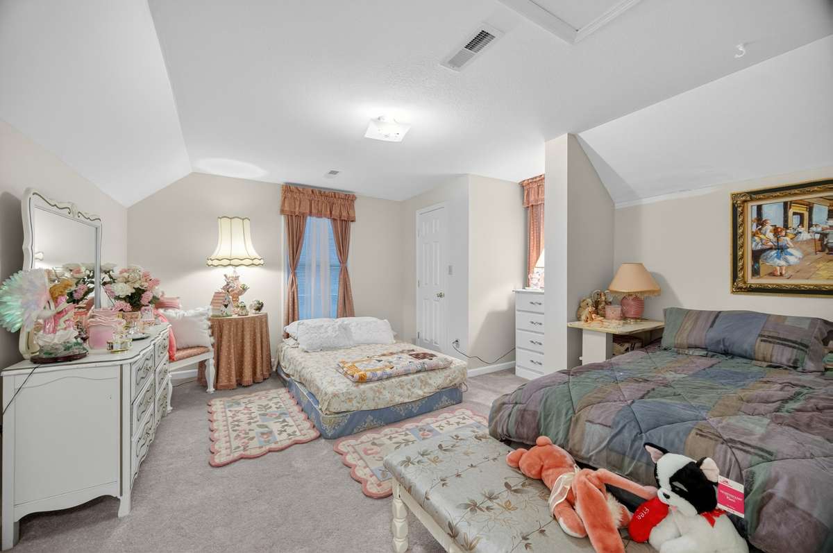 Spacious guest bedroom featuring soft natural light, neutral finishes, and ample space for multiple beds or flexible sleeping arrangements; furnishings may be included, partially included, or removed based on buyer preference.