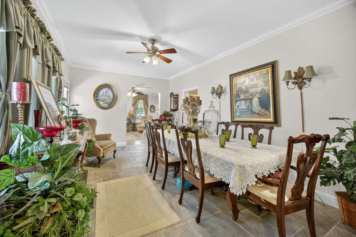 Formal dining room featuring generous proportions, crown molding, and easy flow to adjoining living spaces—ideal for hosting dinners and gatherings; furnishings may be included, partially included, or removed based on buyer preference.