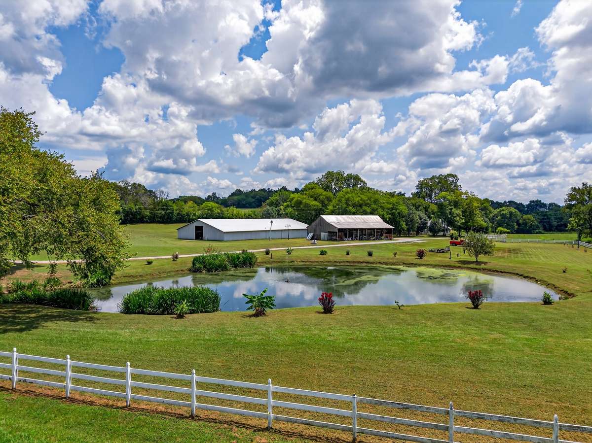 Welcome to Shadow Valley at 54 Warden Road. A serene pond anchors the property, surrounded by open pasture, barns, and wide-open skies—an ideal focal point for weddings, gatherings, recreation, or peaceful country living in a truly private setting.