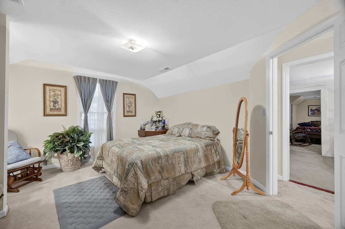 Generously sized bedroom with neutral finishes and flexible layout, ideal for everyday living or guest accommodations; room may be conveyed fully furnished, partially furnished, or unfurnished.