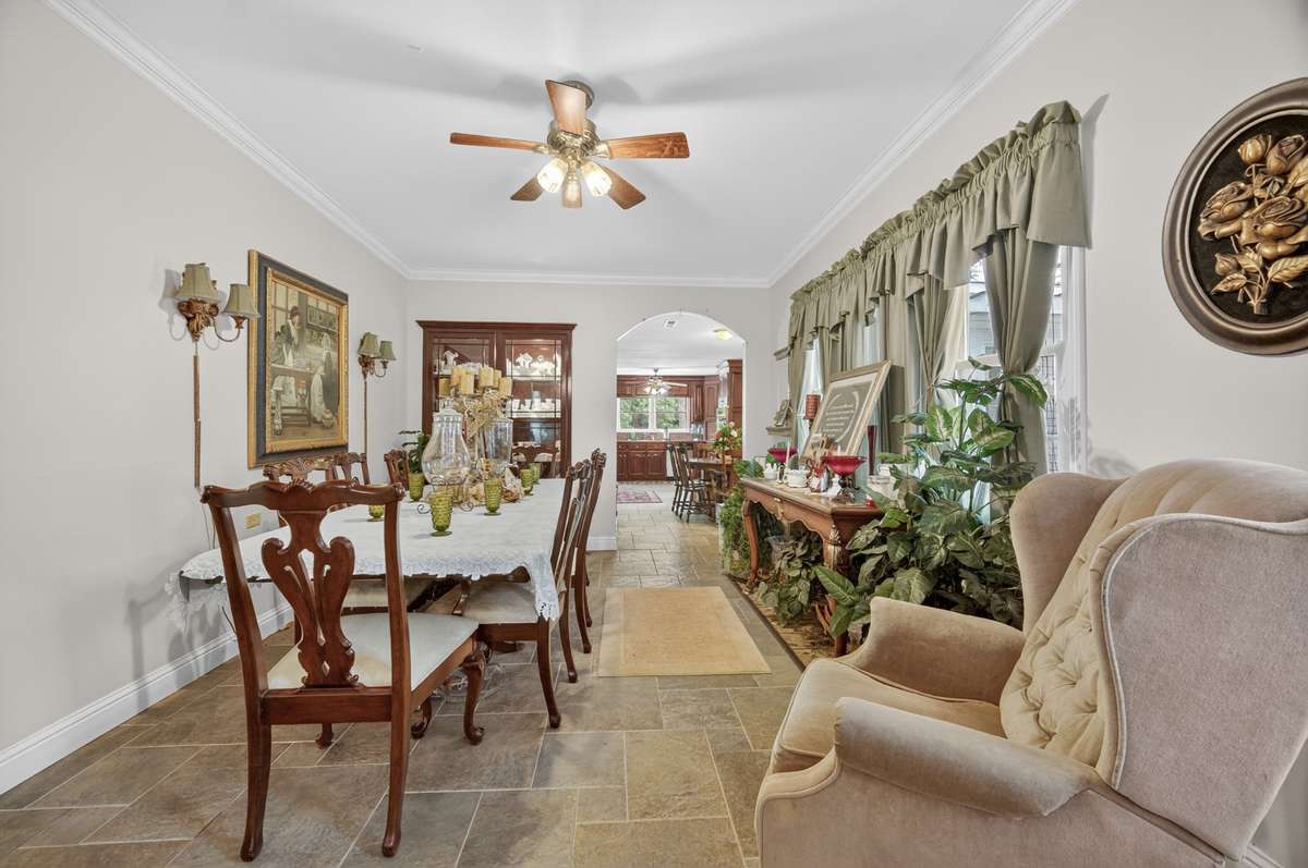 Formal dining room with ample space for entertaining, classic finishes, and convenient access to surrounding living areas; furnishings may be included, partially included, or removed based on buyer preference.