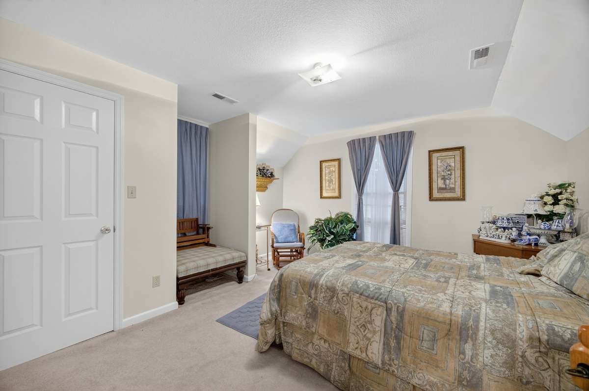 Alternate view of a generously sized bedroom, showcasing vaulted ceiling lines, closet access, and flexible layout suitable for a primary or guest bedroom; furnishings may be included, partially included, or removed based on buyer preference.