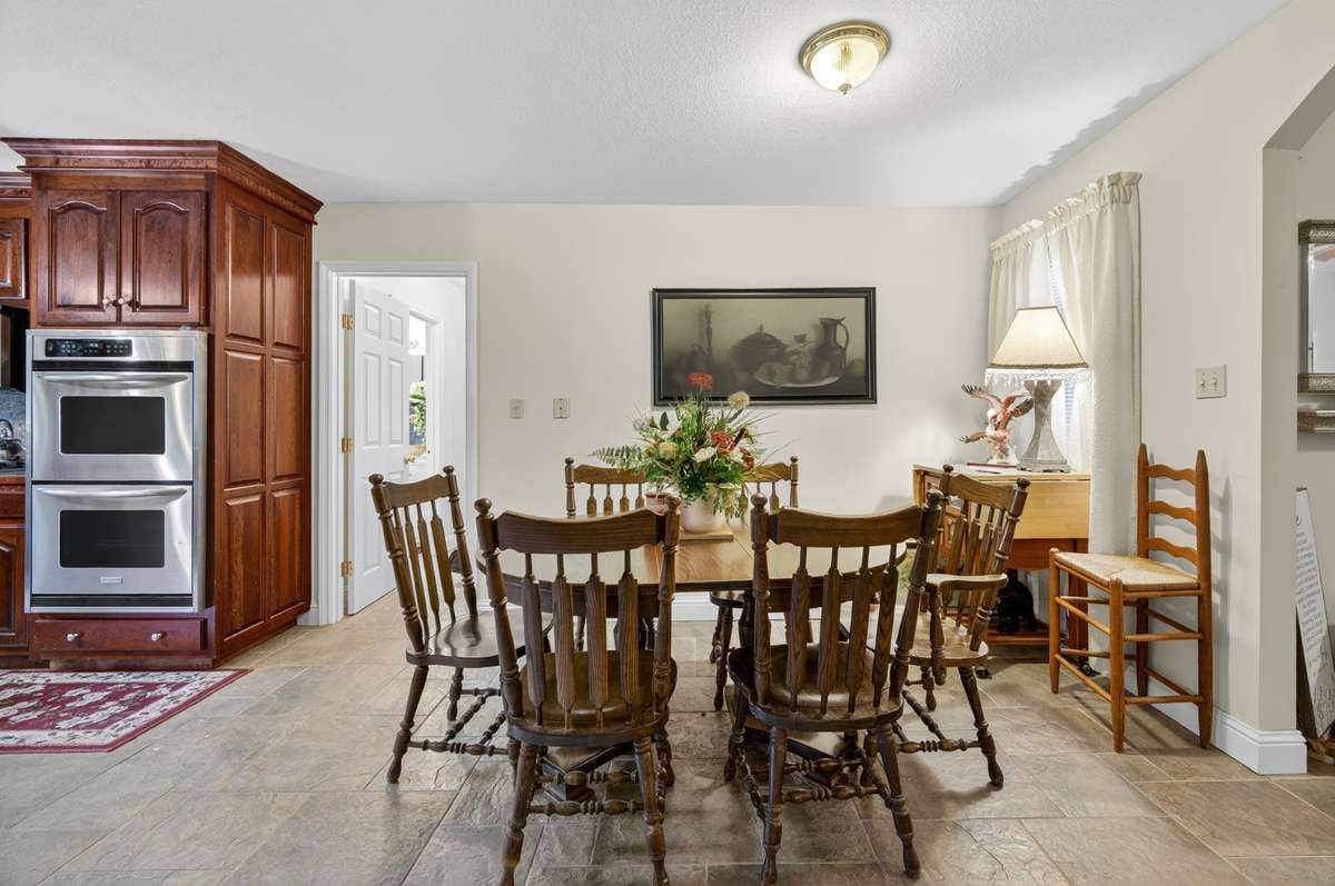 Dedicated dining area adjacent to the kitchen, offering comfortable space for everyday meals or gatherings, with easy flow to surrounding living areas; furnishings may be included, partially included, or removed based on buyer preference.