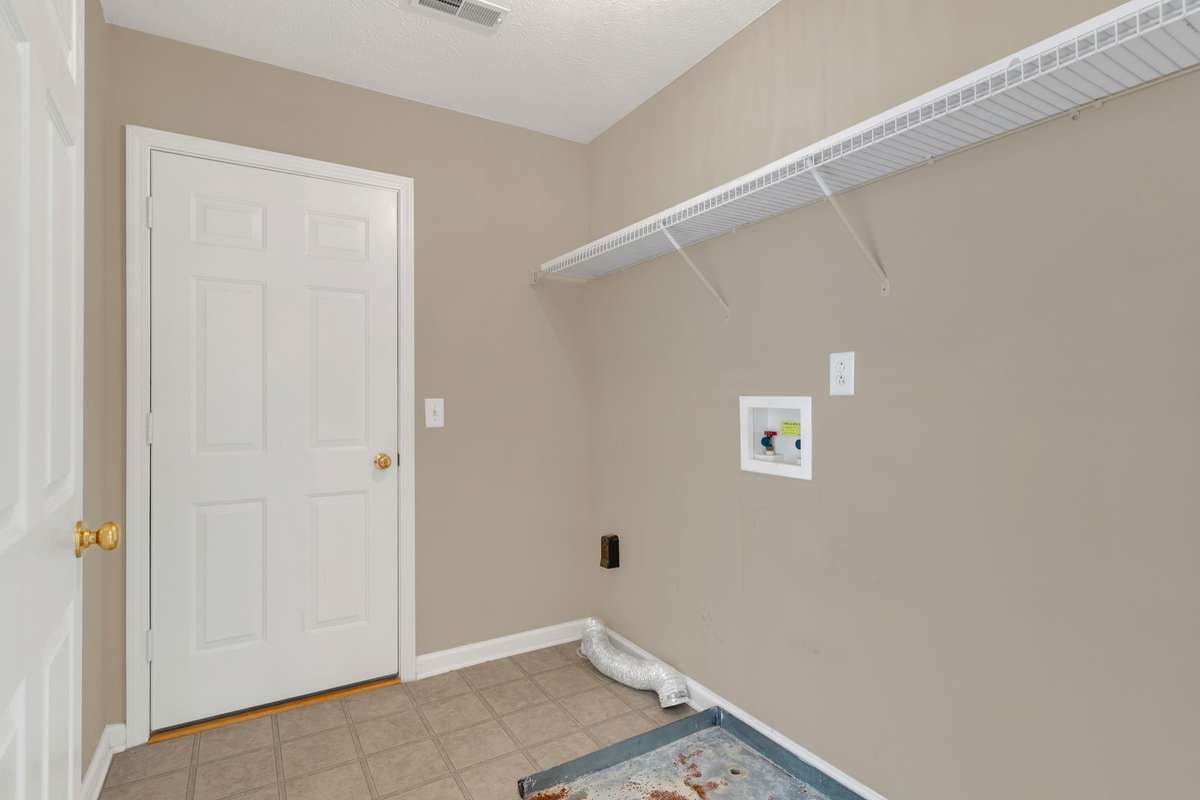 Upstairs laundry room.  Door leads to unfinished storage room.