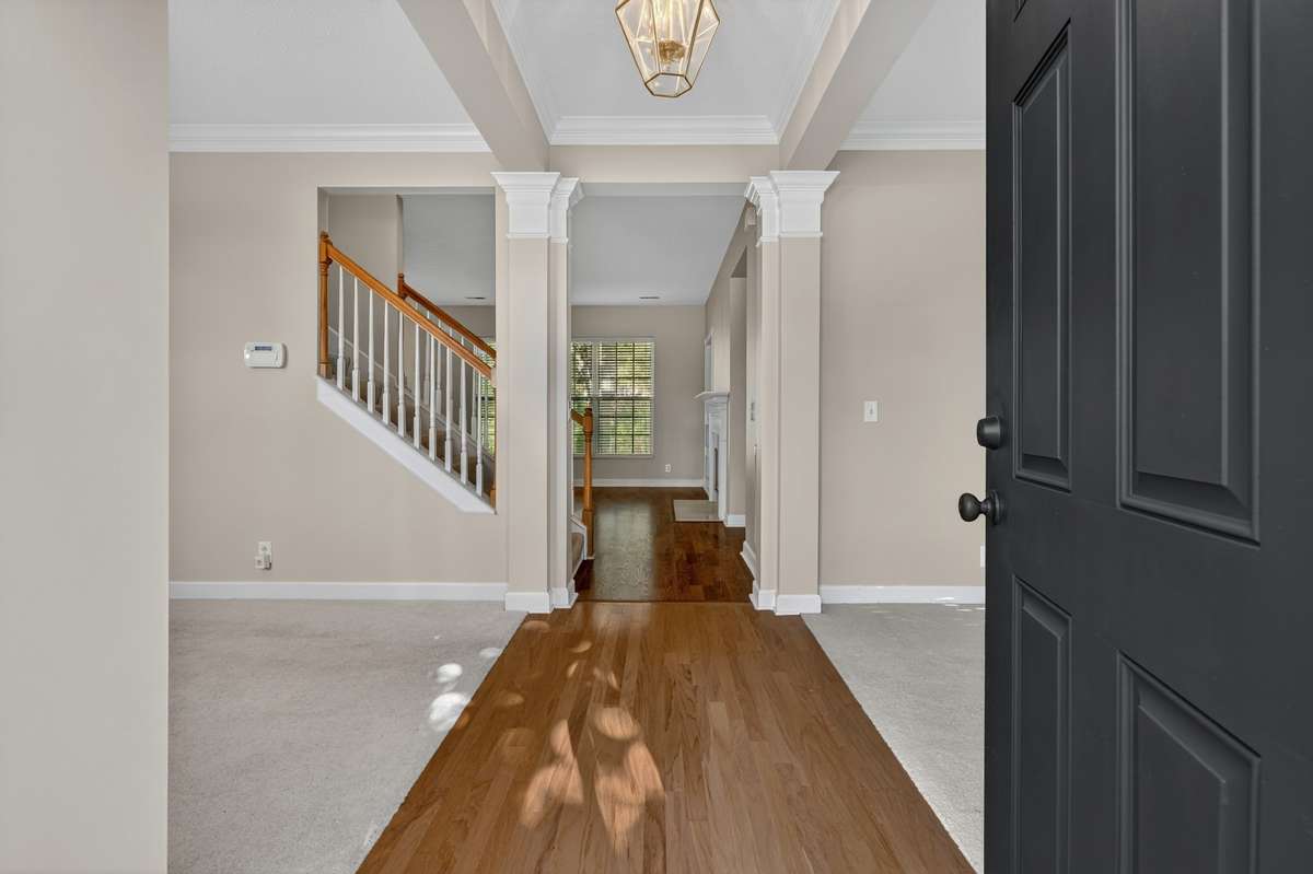 Foyer with hardwood and formal dining room to the left and formal living room to the right.  Double crown molding in both!