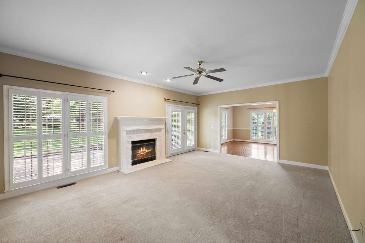 Den with Fireplace & View of Patio & Backyard