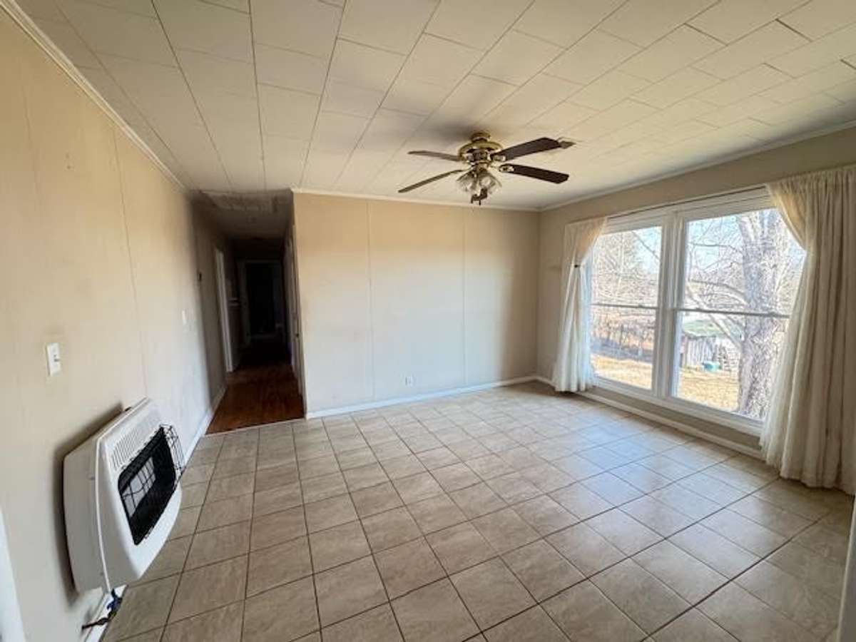 Dining room with floor to ceiling windows overlooking the back yard and room for a large dining room table for meals. Backup gas wall heater for emergencies such as storms.