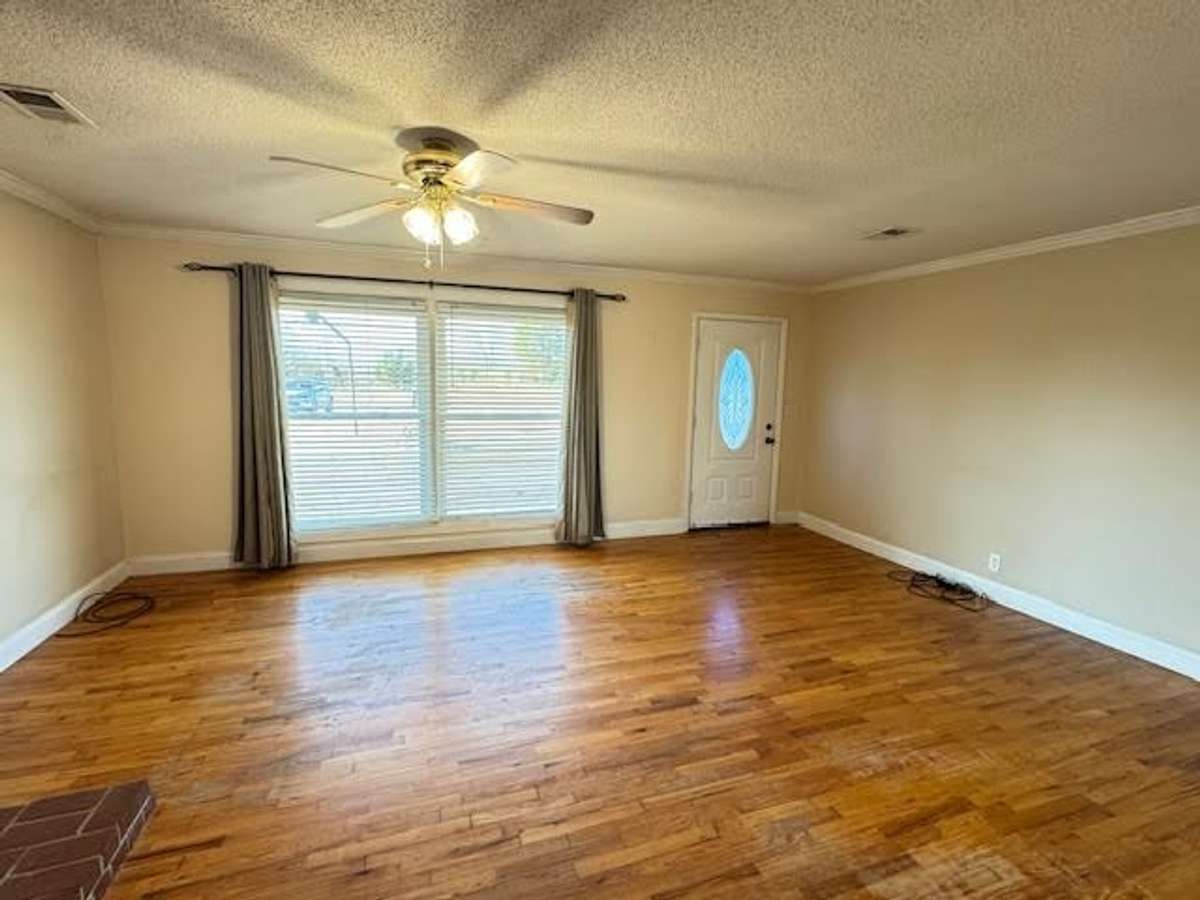 Living room with floor to ceiling windows, hardwood floors and big enough for sectionals and recliners for the entire family