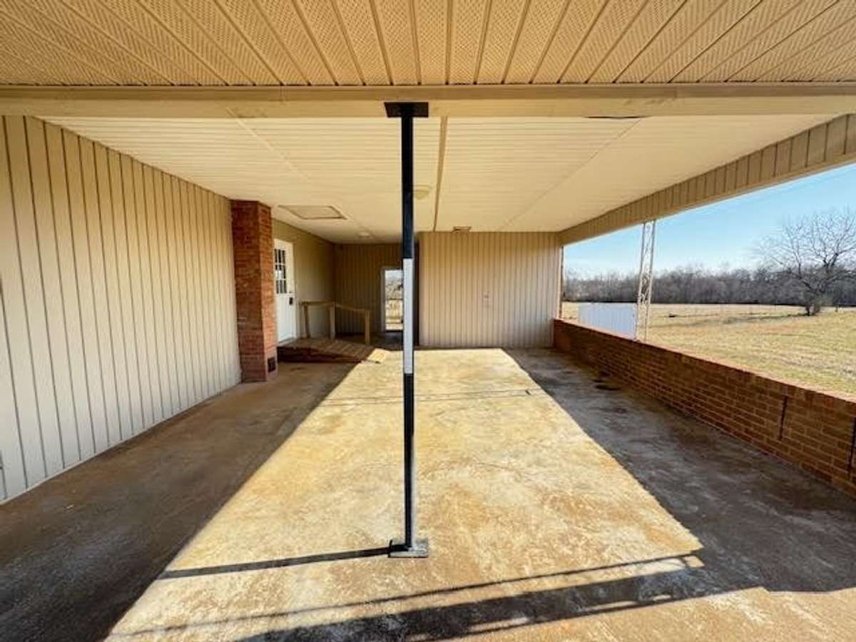 Two car attached carport with attached storage and access to rear porch