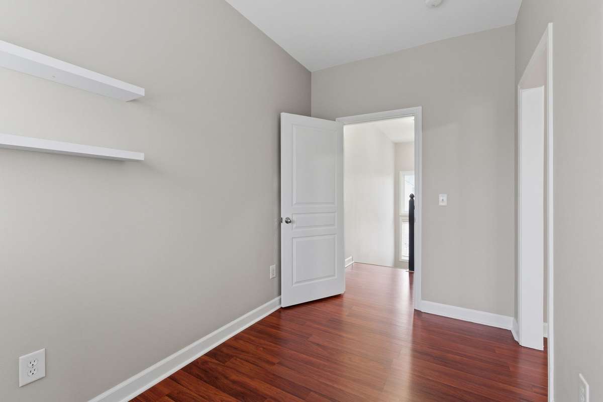 Upstairs flex space off the primary bedroom with built-in shelving and natural light. Ideal for a home office, dressing space, or nursery.