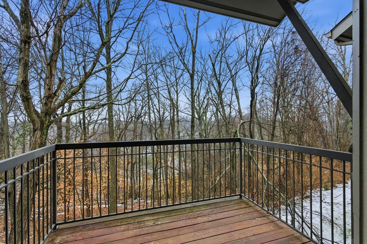 Private covered balcony overlooking a peaceful, wooded valley.