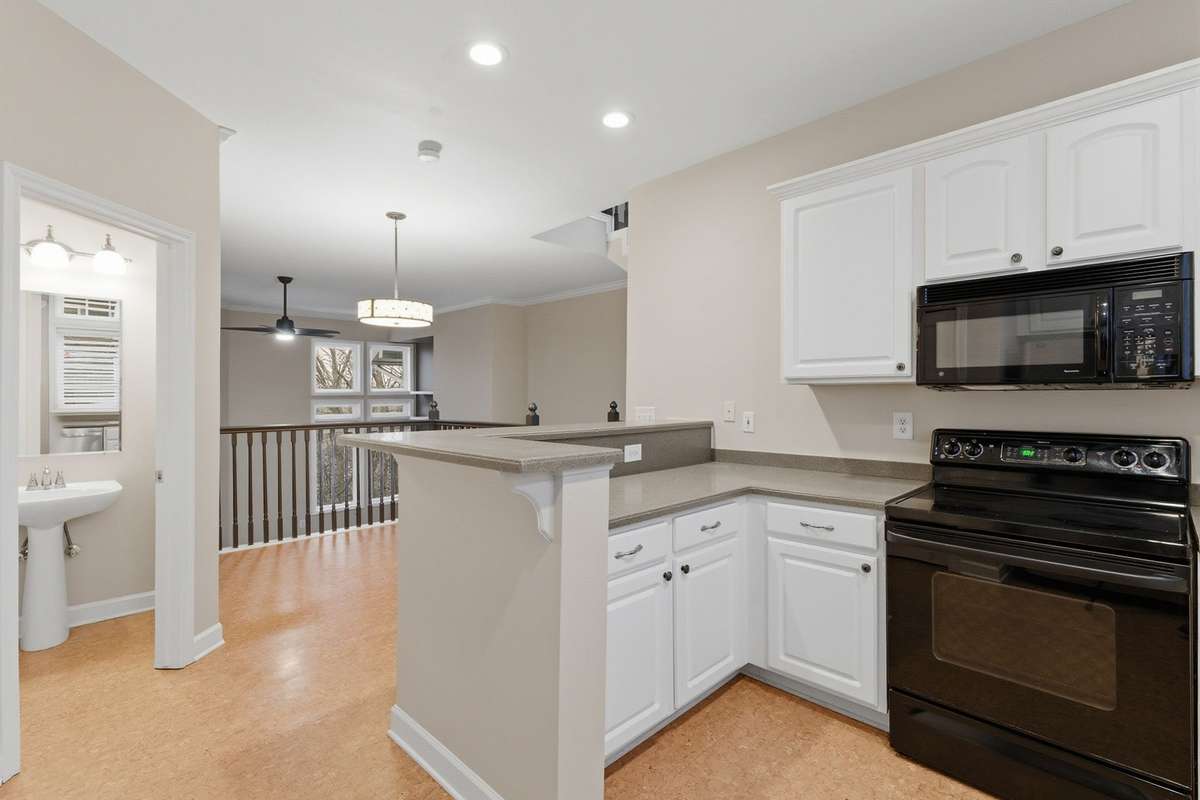 Open-concept kitchen with convenient laundry area — washer and dryer remain — plus a powder room.