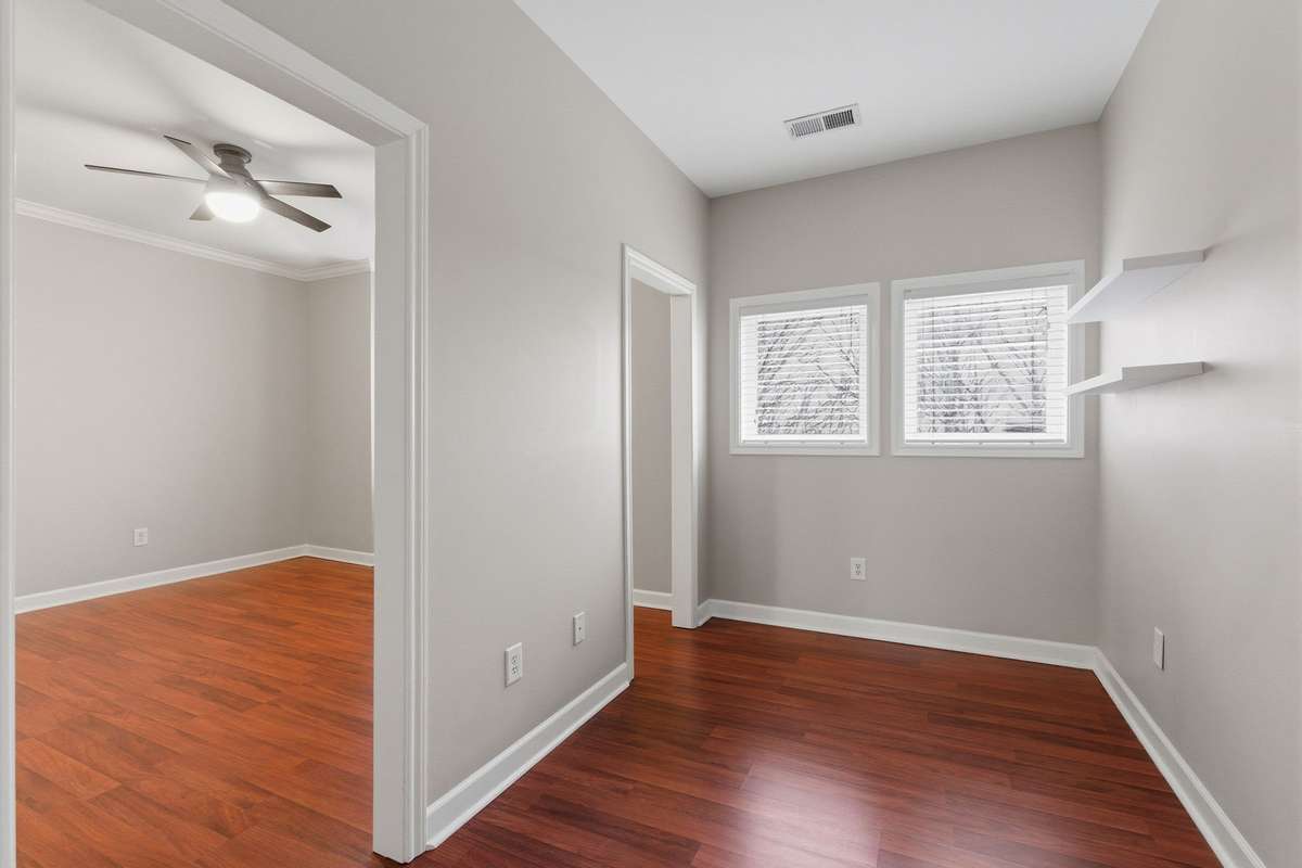 Alternate view of the upstairs flex space showing the open connection to the primary bedroom and additional windows providing natural light, creating a bright and versatile extension of the suite.