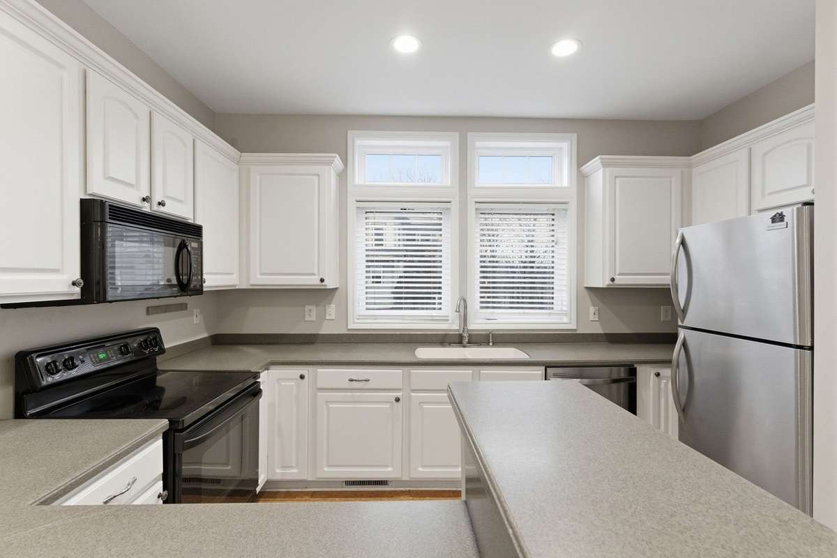 Enjoy a bright, airy kitchen with expansive windows over the sink, flooding the space with natural light! Perfect for everyday living and entertaining. Refrigerator remains.