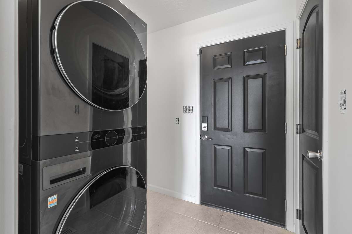 New washer and dryer showing garage door and pantry