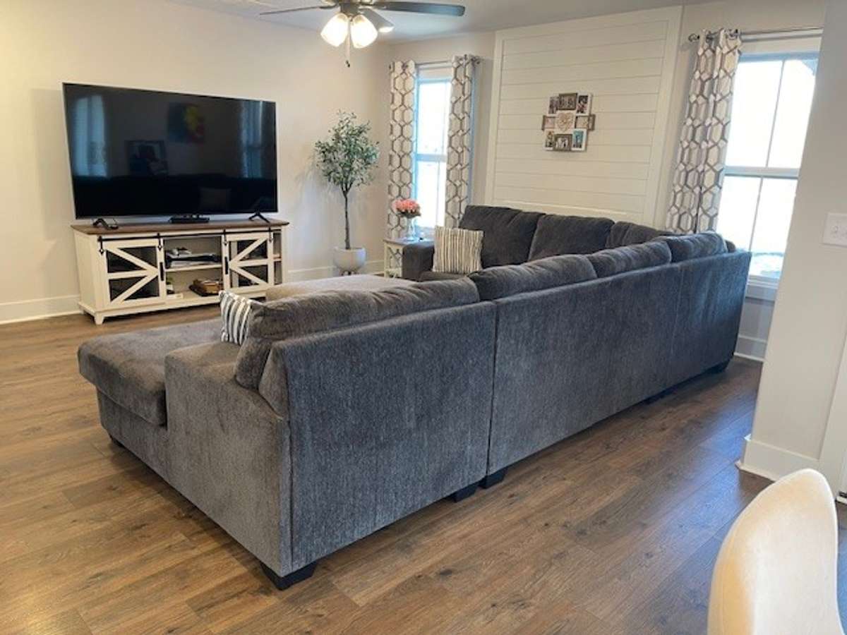 View of Great room. There is a ventless fireplace between the two windows their couch has it covered up.