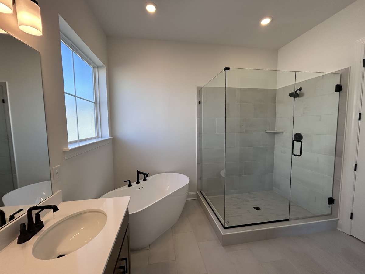 Primary bedroom's Bath with 10 foot ceilings  Stand alone tub and large walkin shower.