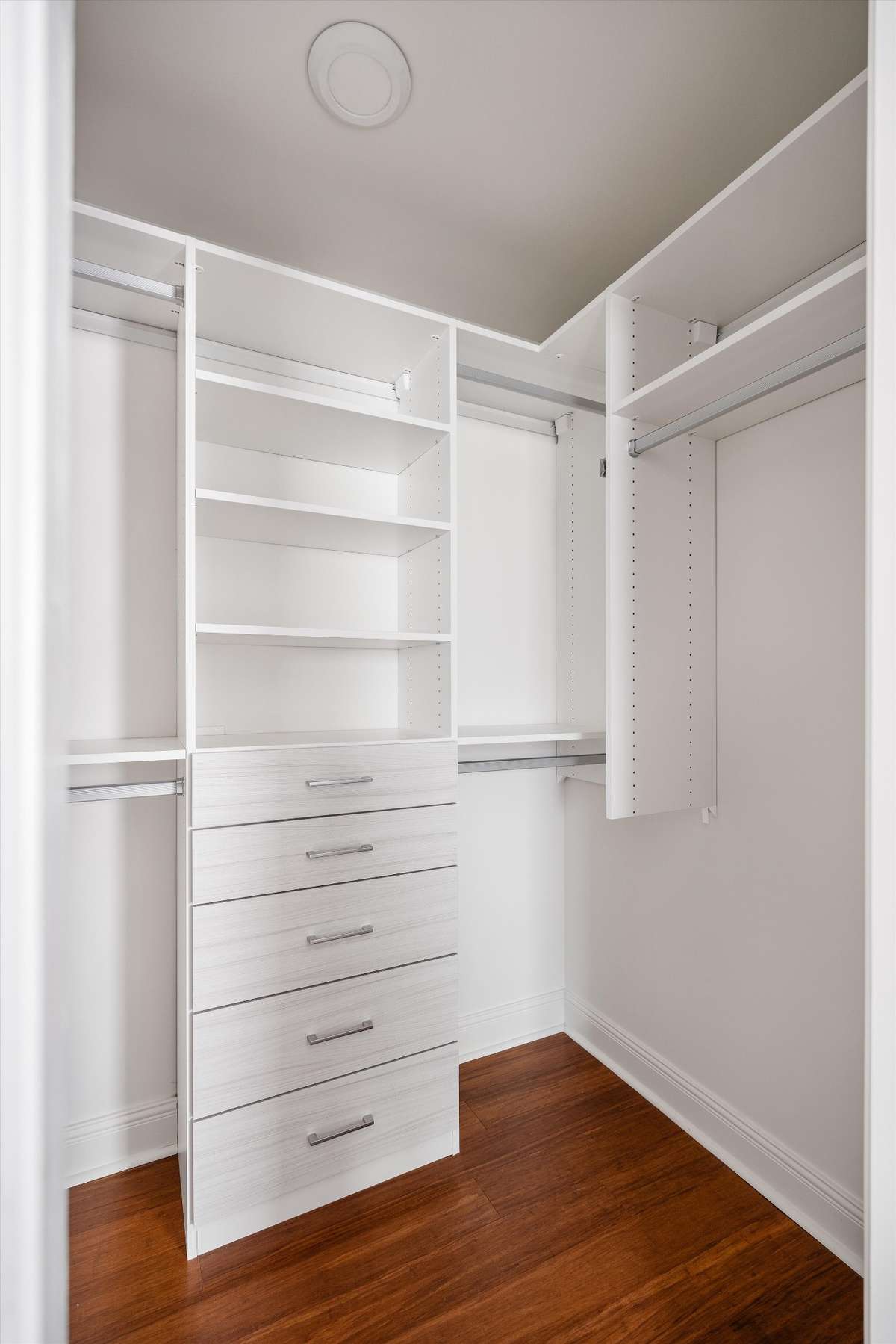 A spacious walk-in closet featuring a custom built-in system for effortless organization.