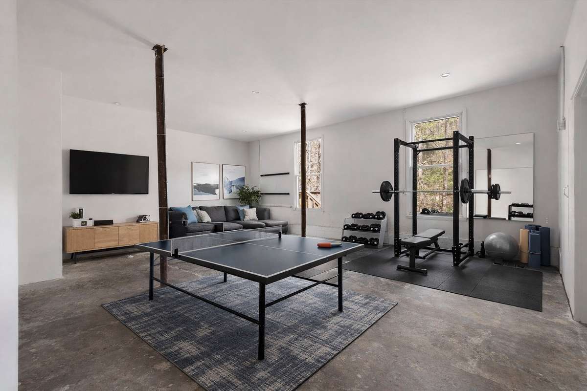 Partially finished basement, virtually staged to showcase its potential as a fitness and game room.