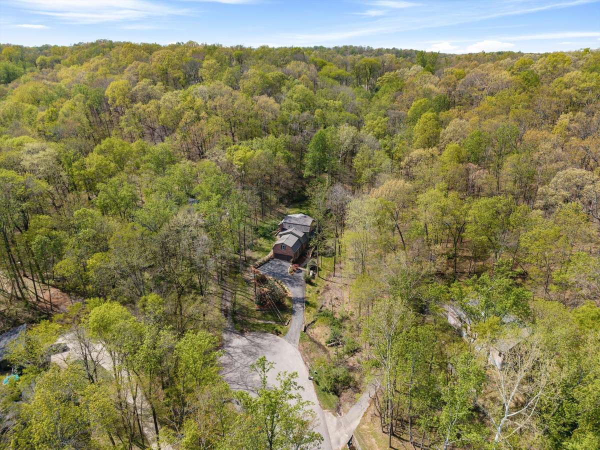 A stunning aerial view of this 2-acre wooded property, offering privacy and a serene cul-de-sac setting.