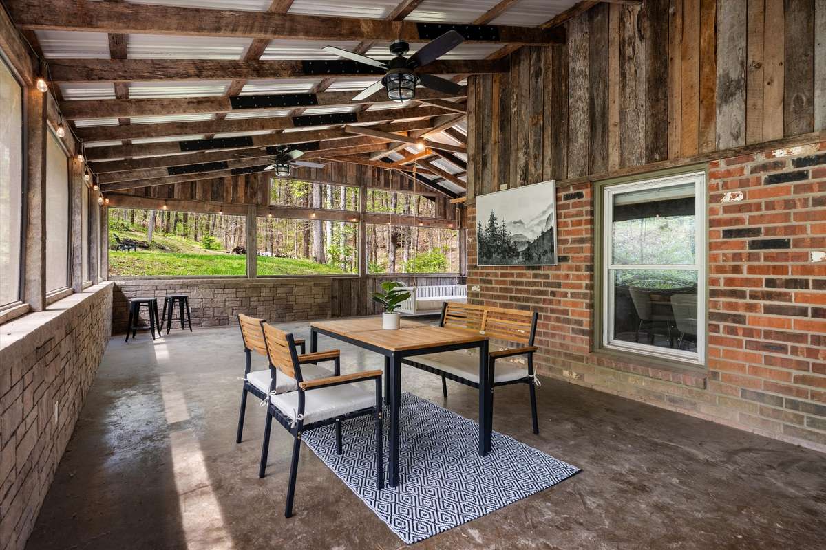 Dine surrounded by nature on this incredible screened-in porch, where wooded views and peaceful sounds create the perfect backdrop.