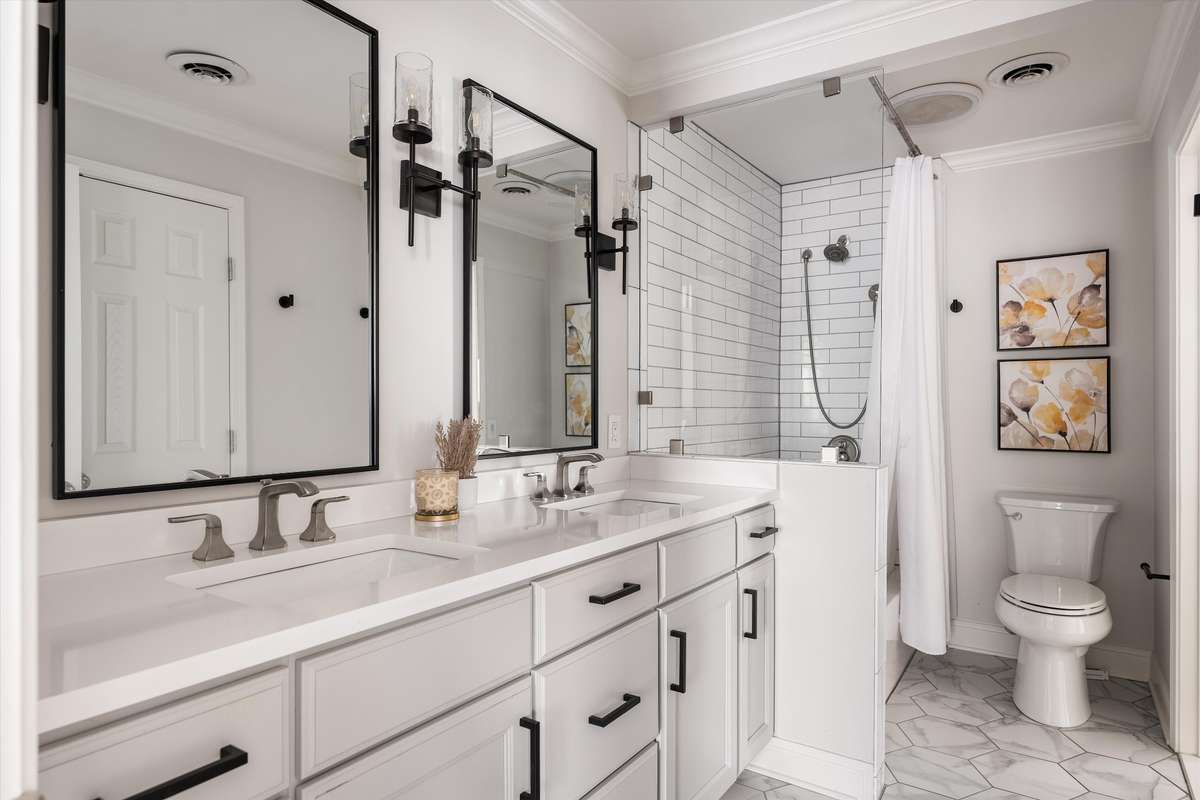 A beautifully updated bathroom featuring double vanities and a stunning walk-in shower.