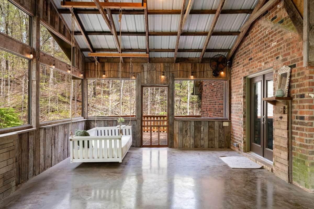 The porch bed swing is the perfect spot to relax, read, or simply take in the serene wooded views.