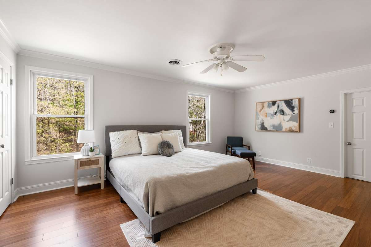 This bright and airy bedroom offers abundant natural light and a walk-in closet with a built-in organization system.