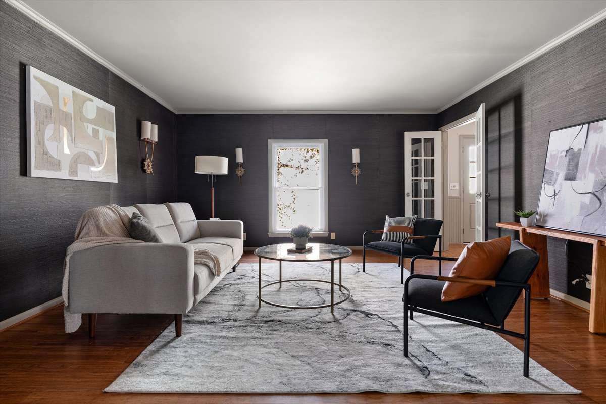 Moody grasscloth walls paired with warm gold sconces create the perfect space to unwind and gather.