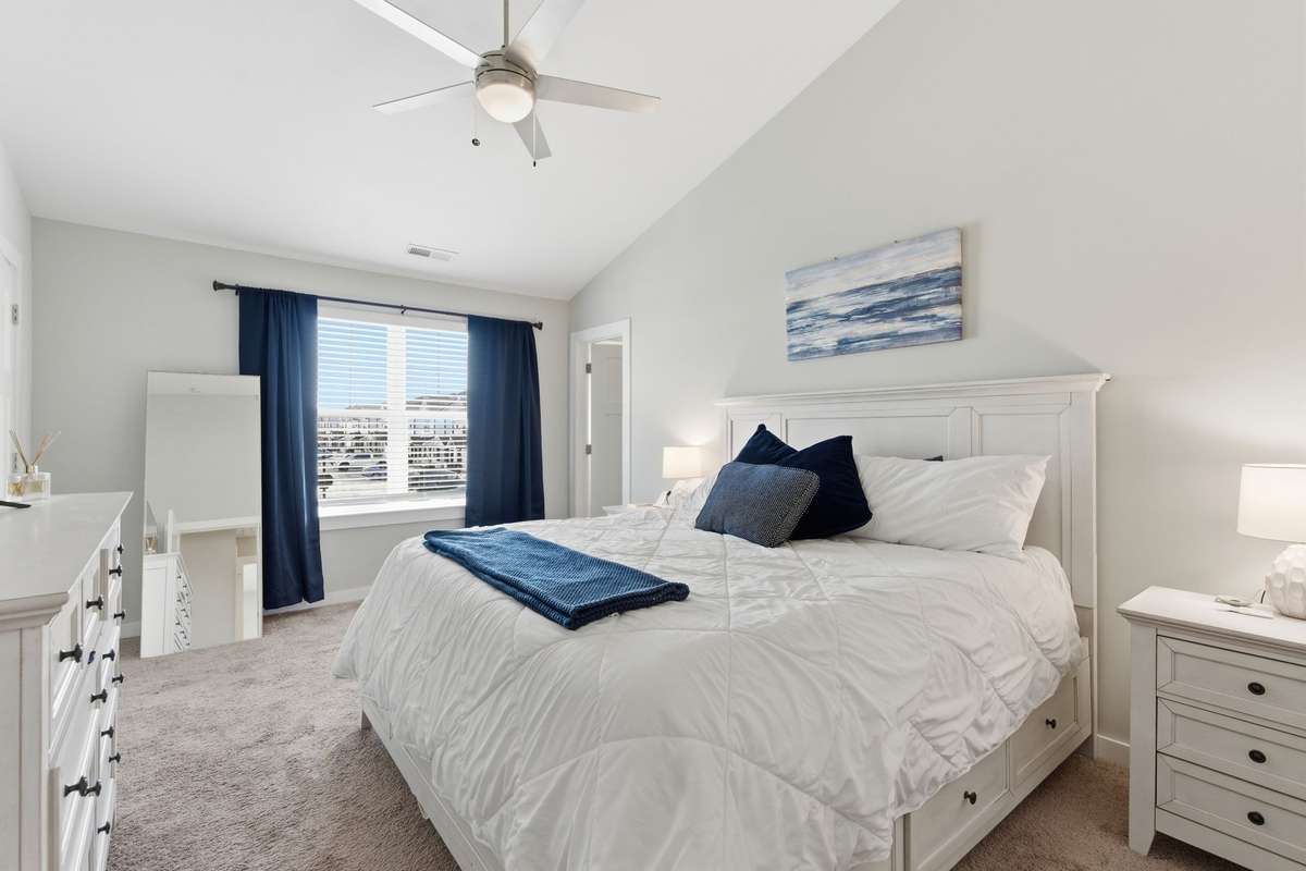 Escape to the primary bedroom featuring high ceilings and ample space for relaxation.
