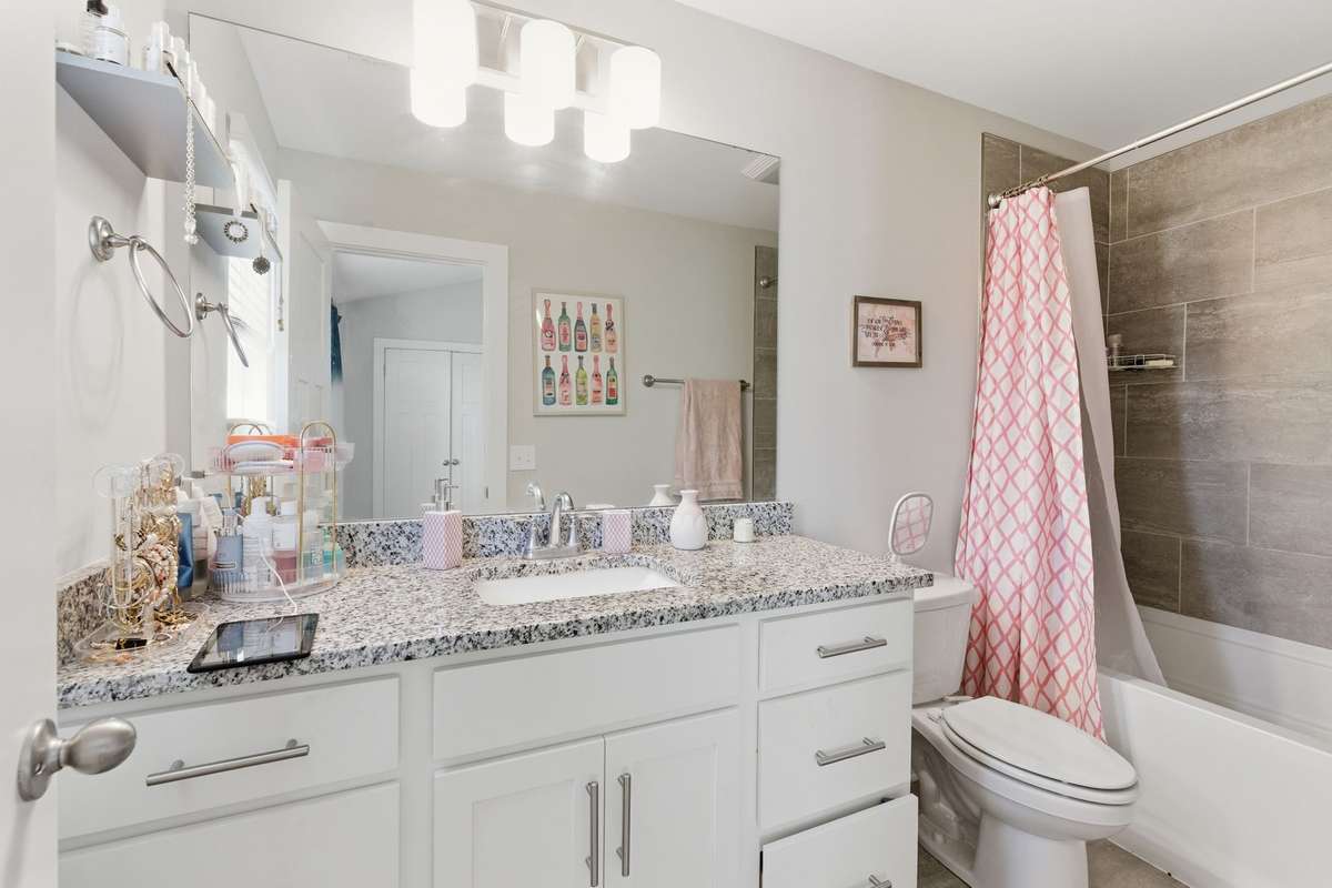 Unwind in the private primary bathroom with ample counter and cabinet space.