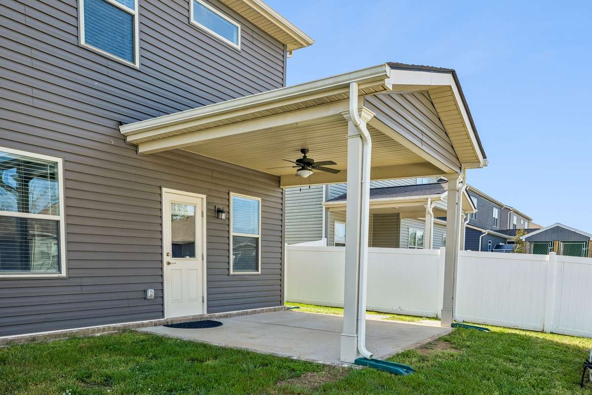 Step outside onto this large covered patio.  Notice the ceiling fan already installed!