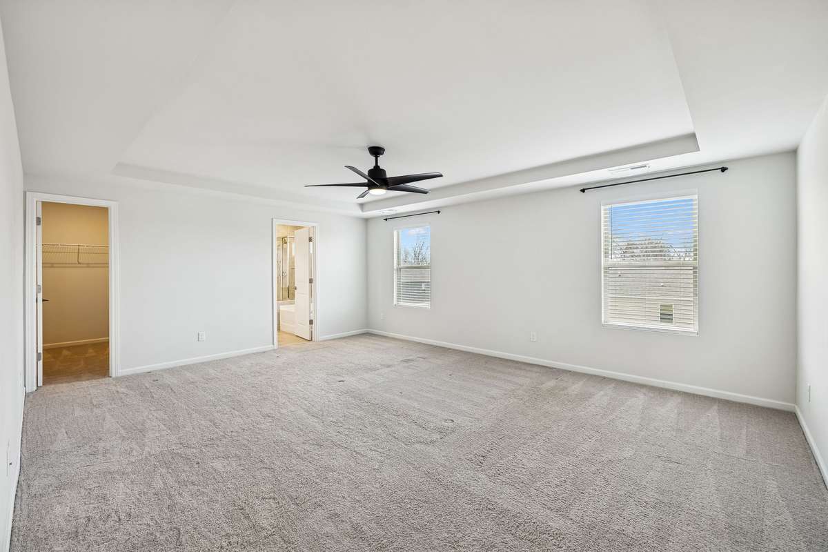 Spacious Primary Suite with tray ceiling and ceiling fan already installed.