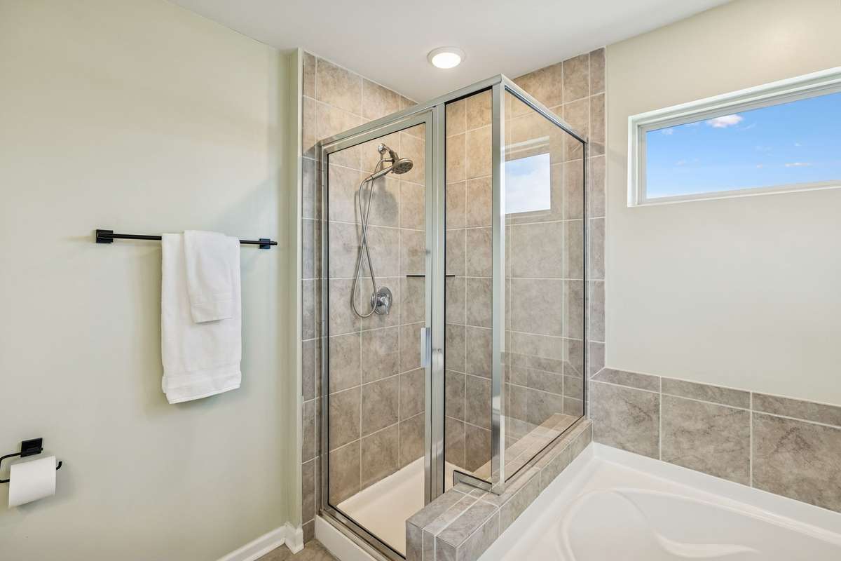 Beautiful step-in floor to ceiling tiled shower.