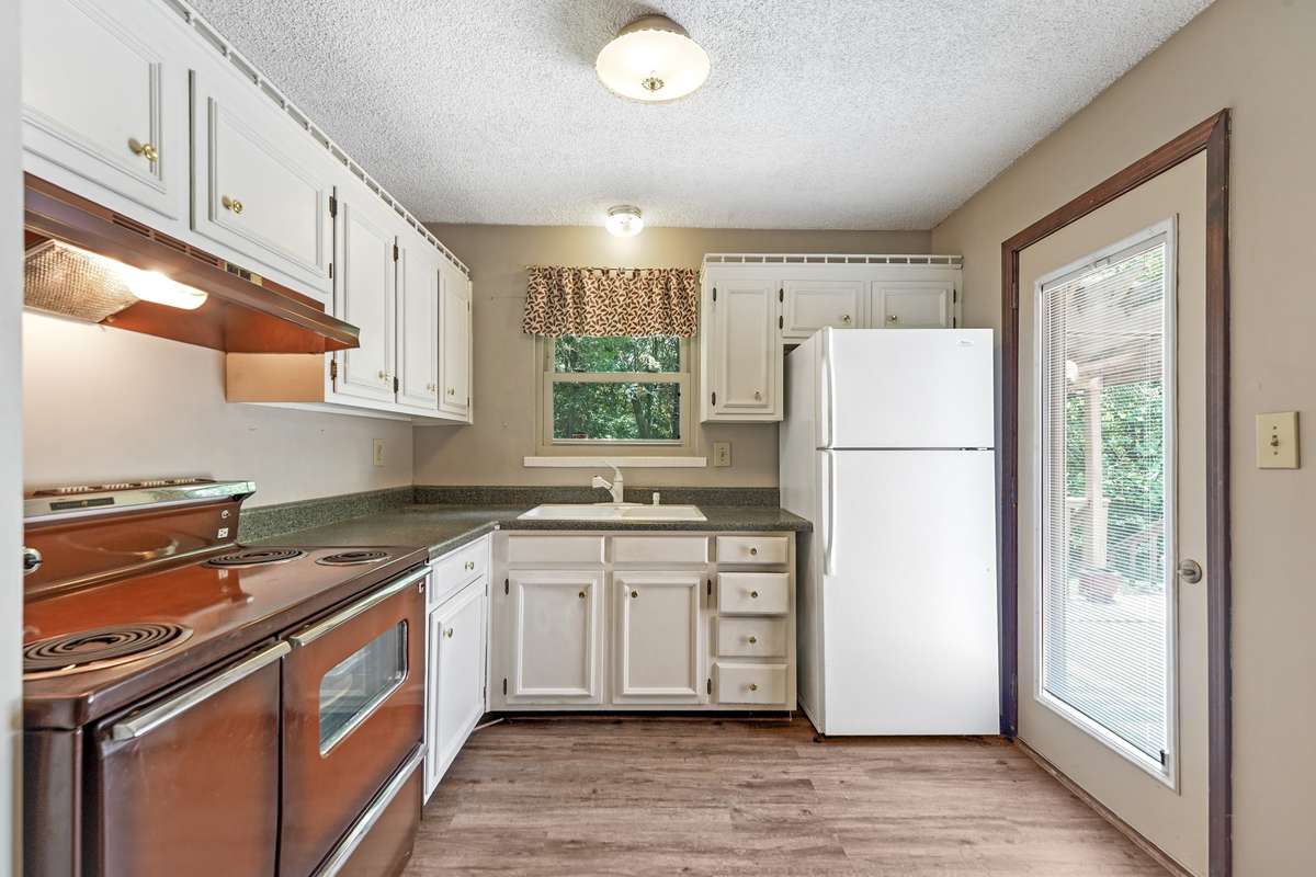 Apartment kitchen with door leading to back deck.