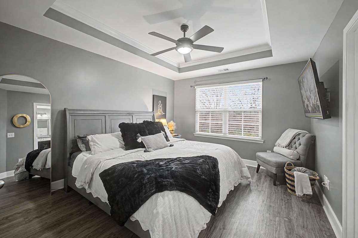 Primary bedroom with LVP flooring and neutral grey tones